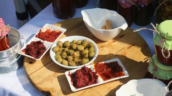 A serving board with olives and red olive pastes
