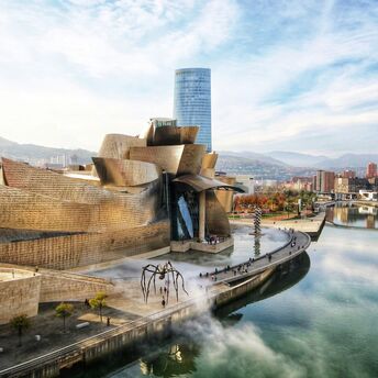Museum exterior of the Guggenheim Bilbao beside the river on a clear day