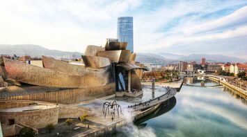 Museum exterior of the Guggenheim Bilbao beside the river on a clear day