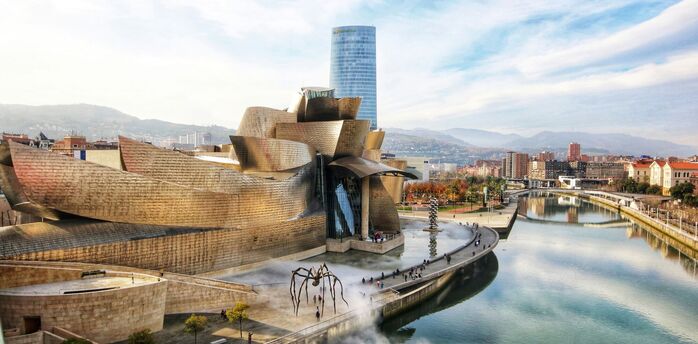 Museum exterior of the Guggenheim Bilbao beside the river on a clear day