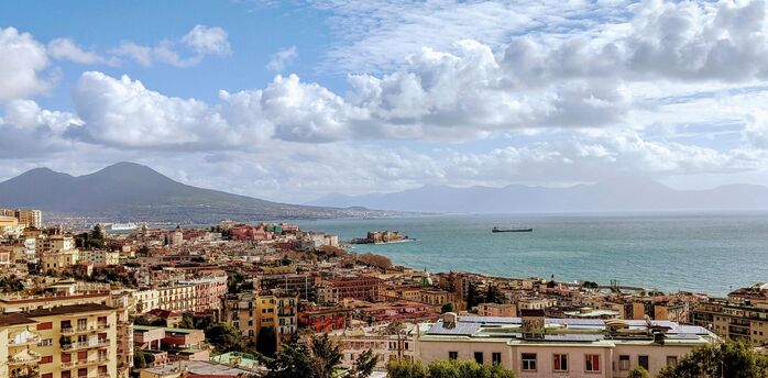 Panoramic view of Naples with Mount Vesuvius and the Gulf of Naples under a partly cloudy sky