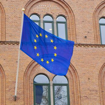 EU flag displayed on historic brick building.