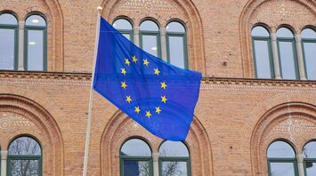 EU flag displayed on historic brick building.