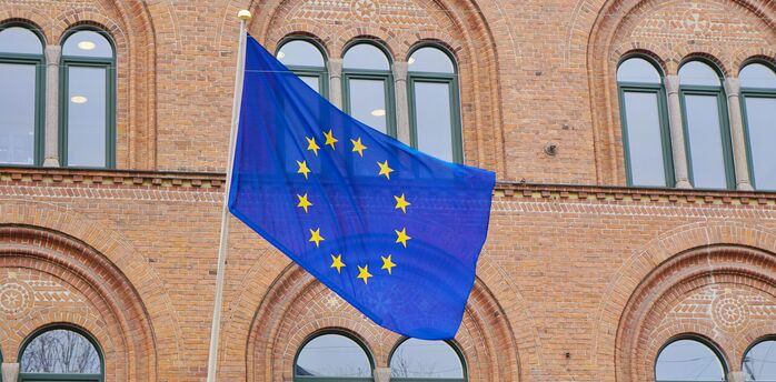 EU flag displayed on historic brick building.