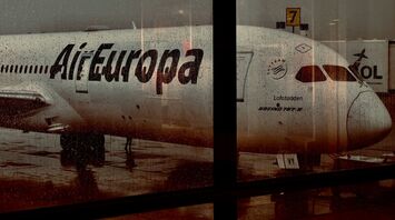 Air Europa aircraft seen through wet airport window