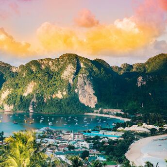 View of tropical bay with limestone cliffs and boats in southern Thailand