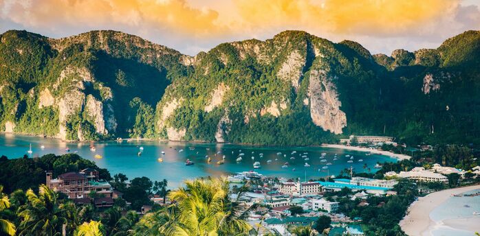 View of tropical bay with limestone cliffs and boats in southern Thailand