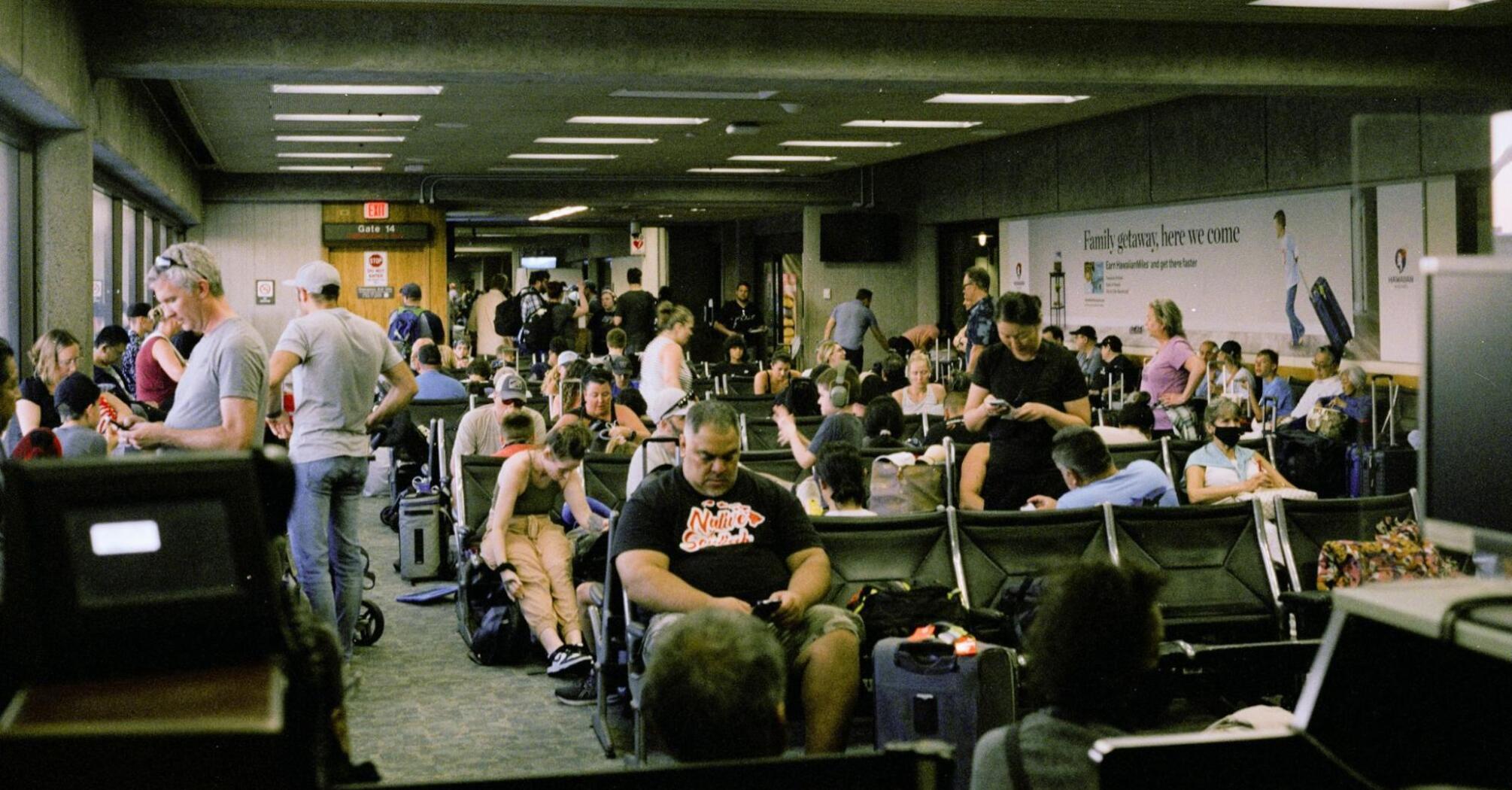 Passengers waiting in a crowded airport terminal