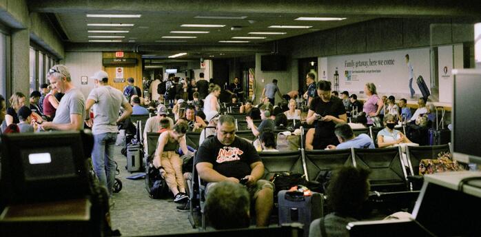 Passengers waiting in a crowded airport terminal