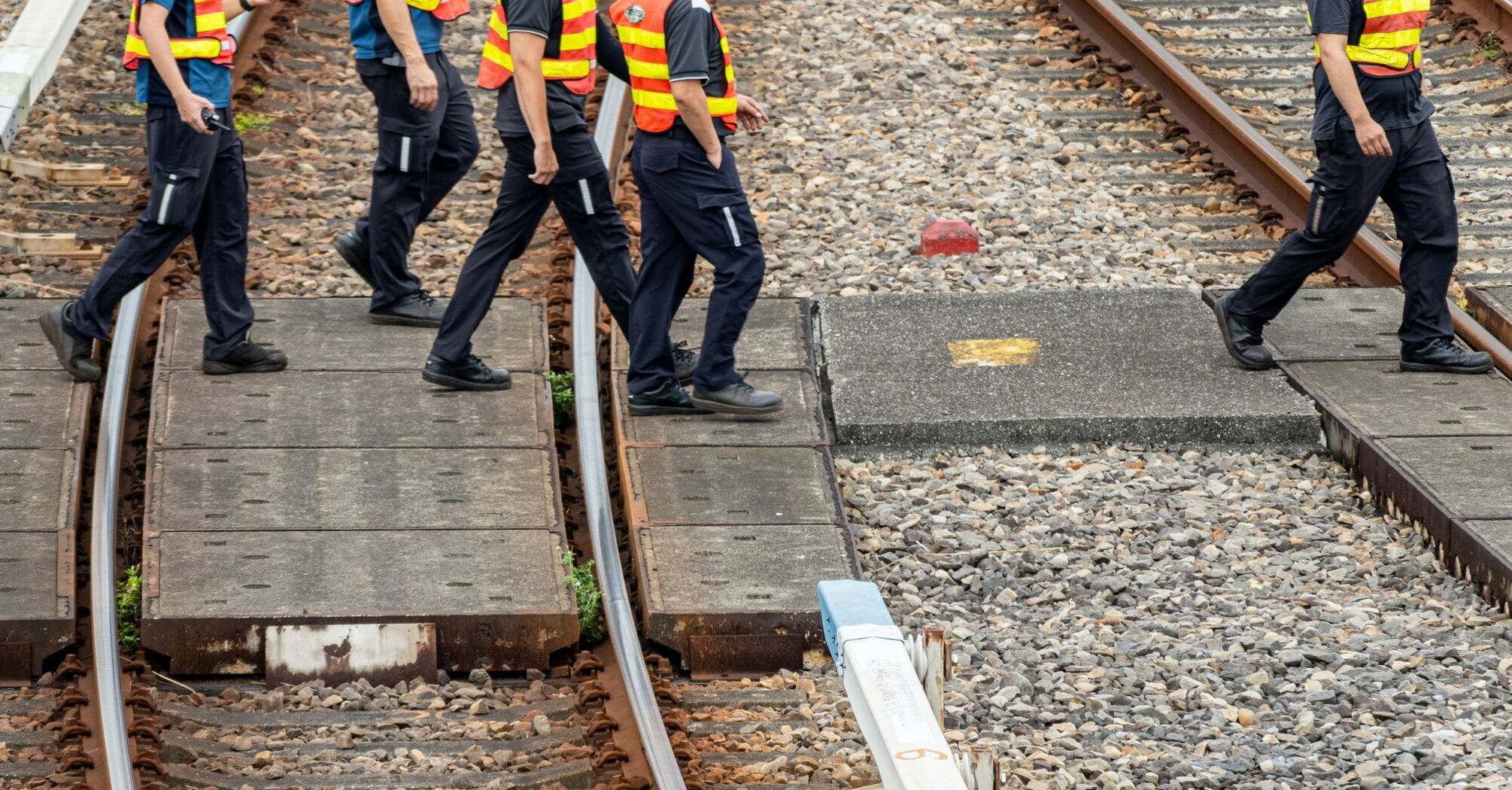 Rail workers walking across tracks during maintenance works