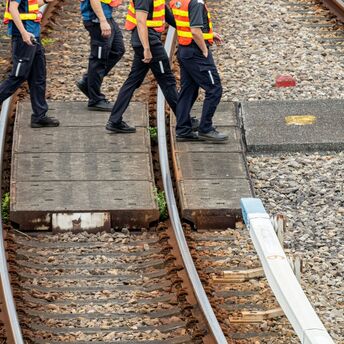 Rail workers walking across tracks during maintenance works