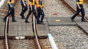 Rail workers walking across tracks during maintenance works