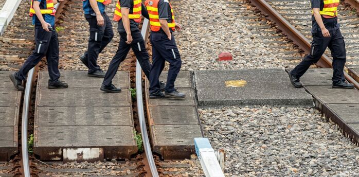 Rail workers walking across tracks during maintenance works