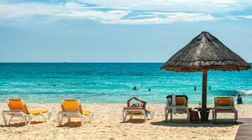 Sun loungers and parasol on a tropical beach