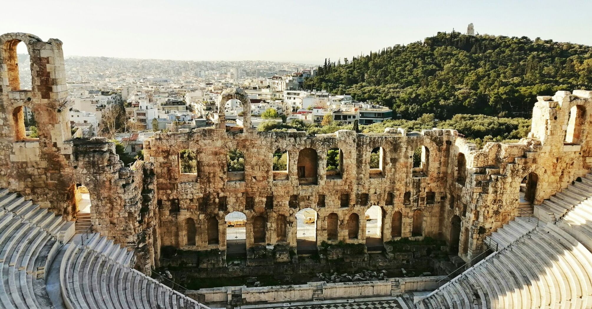 Ancient stone theatre overlooking Athens rooftops and hills
