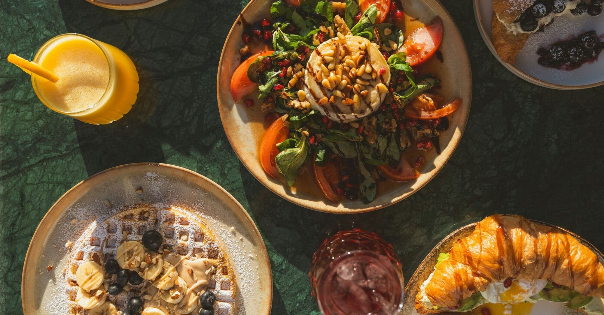 Colourful breakfast and brunch dishes on a table with natural sunlight