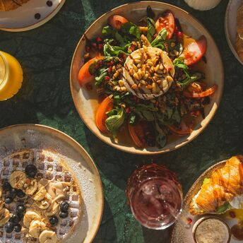 Colourful breakfast and brunch dishes on a table with natural sunlight