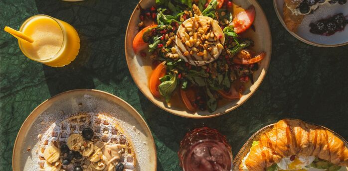 Colourful breakfast and brunch dishes on a table with natural sunlight