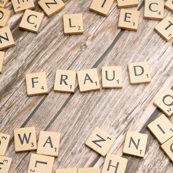 Scrabble tiles forming the word fraud