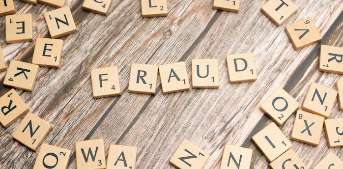 Scrabble tiles forming the word fraud
