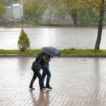 Pedestrians walking in heavy rain during stormy weather