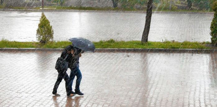 Pedestrians walking in heavy rain during stormy weather