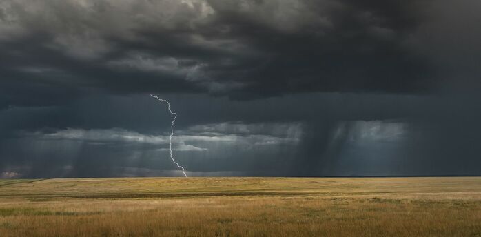 Lightning strike under dark storm clouds
