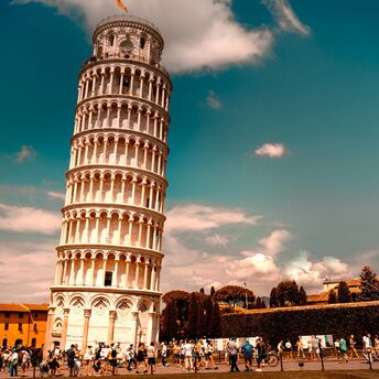 Crowds around the Leaning Tower of Pisa under a bright sky