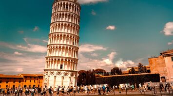 Crowds around the Leaning Tower of Pisa under a bright sky