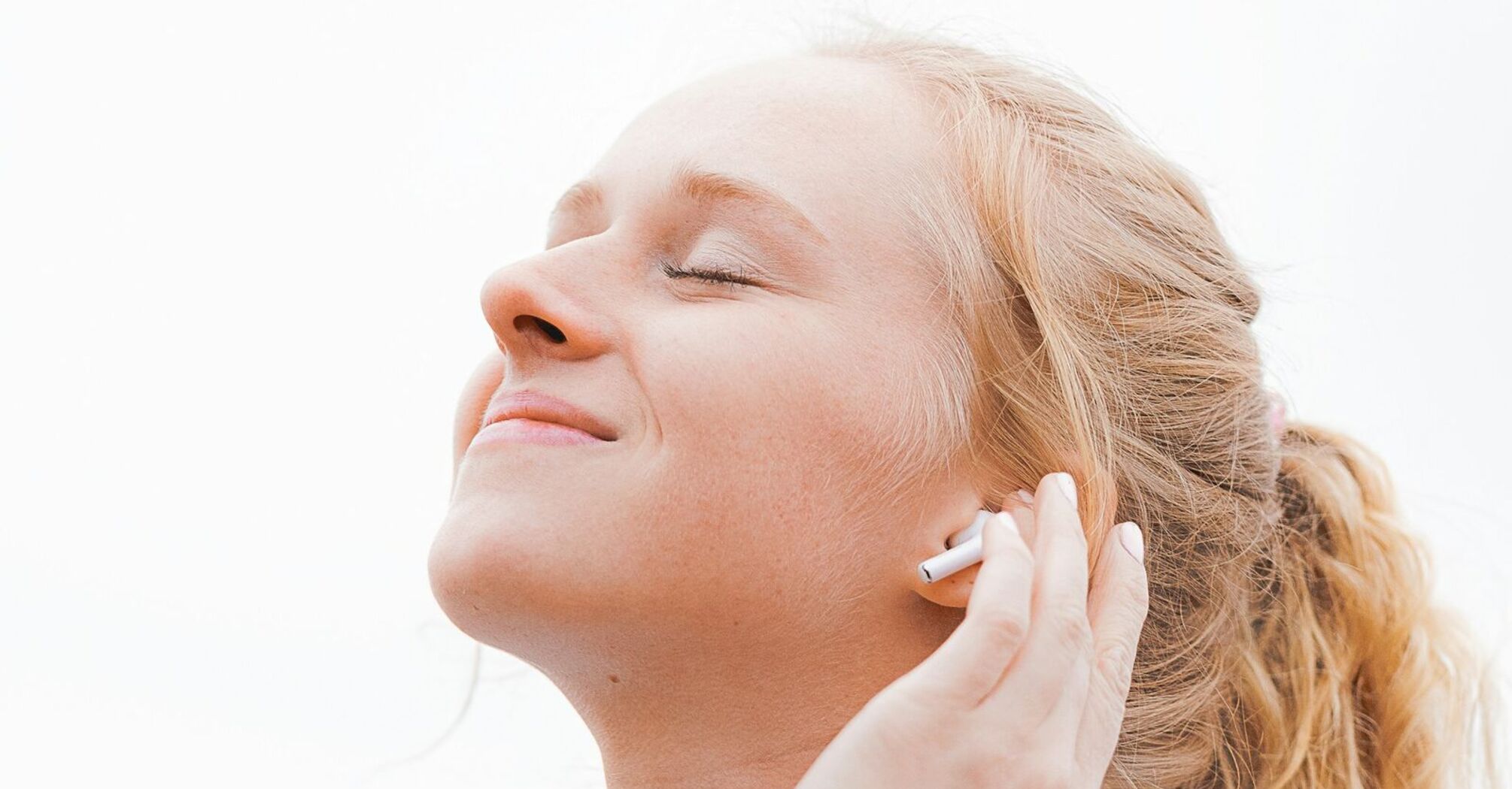 Person wearing wireless earbud and listening