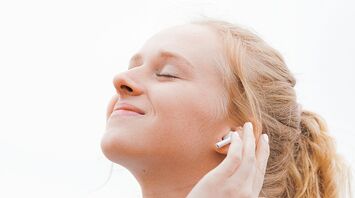 Person wearing wireless earbud and listening