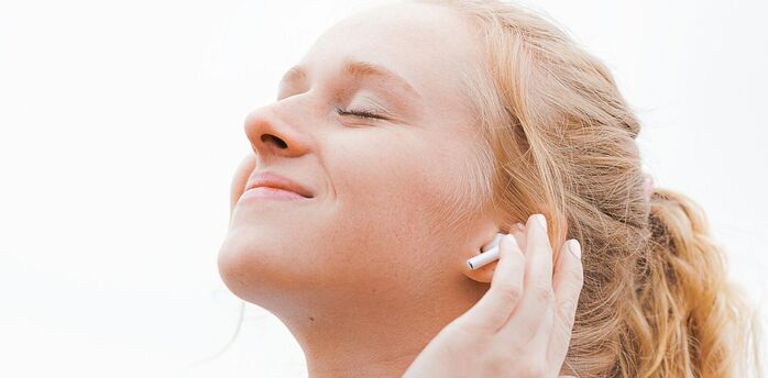 Person wearing wireless earbud and listening