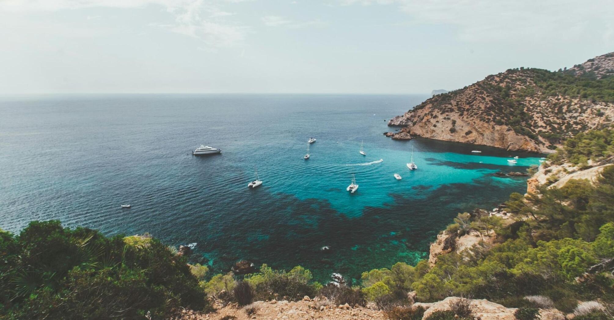 Mediterranean coastline with boats near rocky shore
