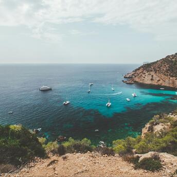 Mediterranean coastline with boats near rocky shore