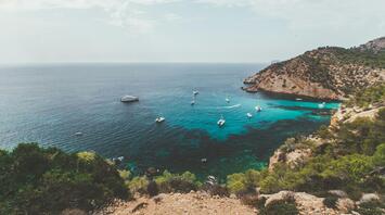 Mediterranean coastline with boats near rocky shore