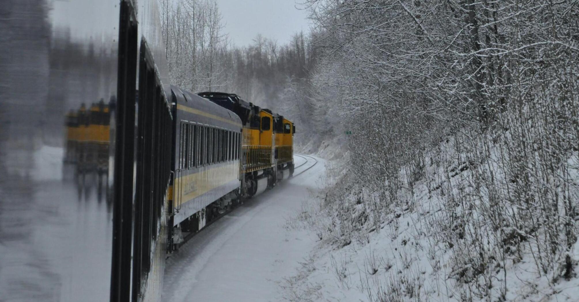 Train travelling through snowy countryside during winter weather