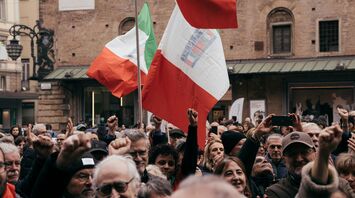 Crowd holding Italian flags during a national strike.