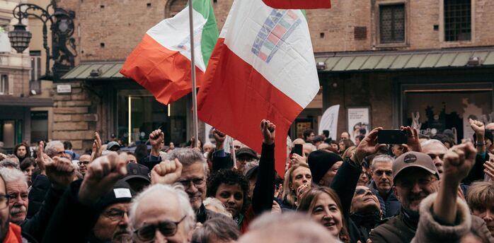 Crowd holding Italian flags during a national strike.