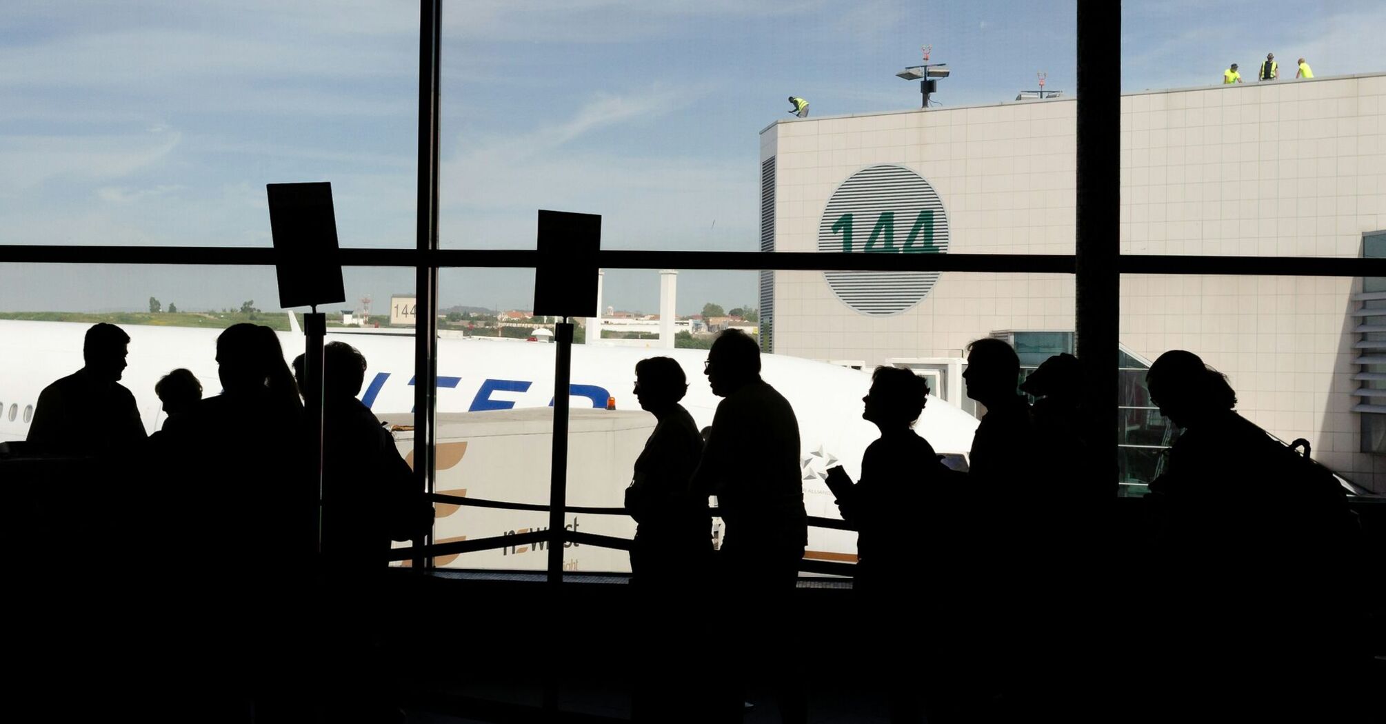 Passengers queue inside an airport terminal