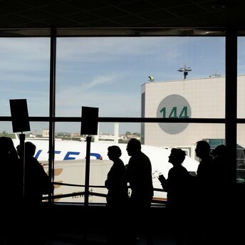 Passengers queue inside an airport terminal