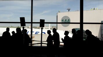 Passengers queue inside an airport terminal