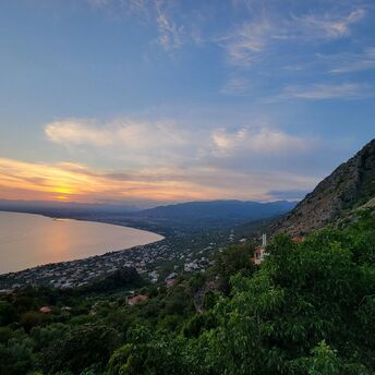 Coastal view of Kalamata at sunset with mountains and sea