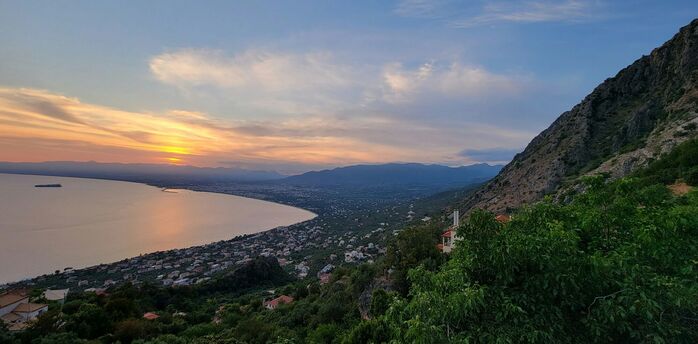 Coastal view of Kalamata at sunset with mountains and sea