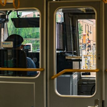 Train approaching on suburban rail line viewed from inside carriage