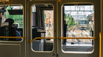 Train approaching on suburban rail line viewed from inside carriage