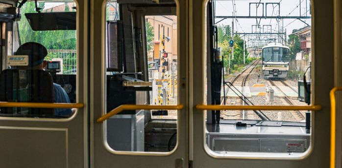 Train approaching on suburban rail line viewed from inside carriage