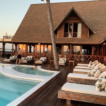 Outdoor hotel pool with wooden sun loungers