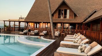 Outdoor hotel pool with wooden sun loungers