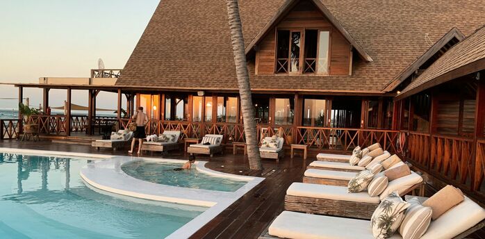 Outdoor hotel pool with wooden sun loungers