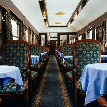 Elegant train dining car with blue upholstered chairs